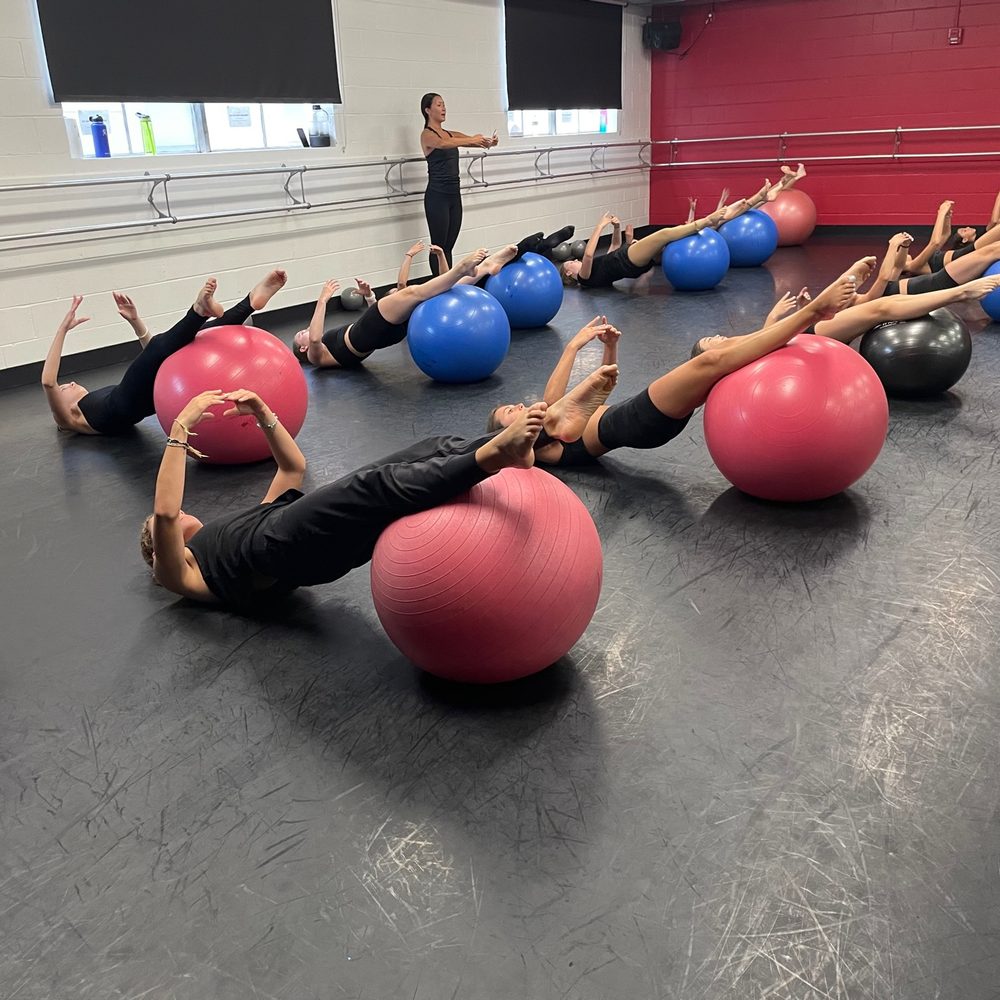 Technique class working on stability balls in the studio