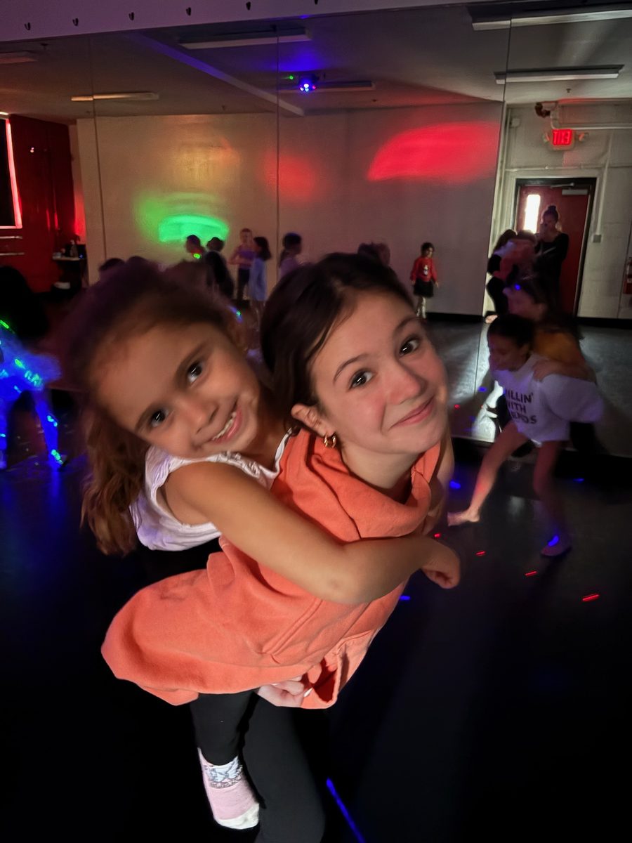 Two friends hugging under the disco lights at an AFDS birthday party